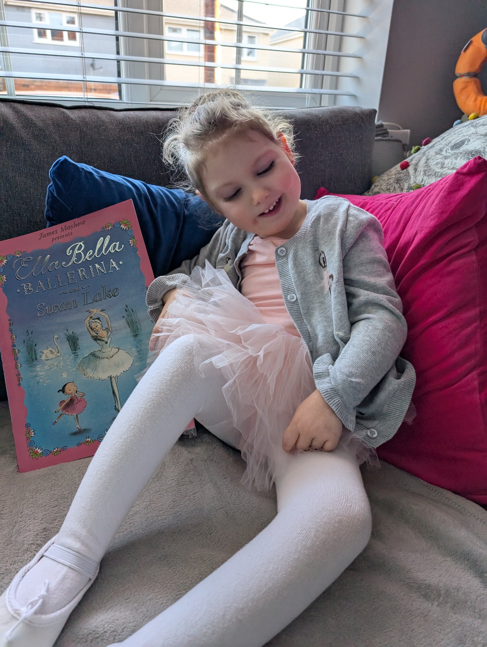 Grace in a ballerina outfit with a book